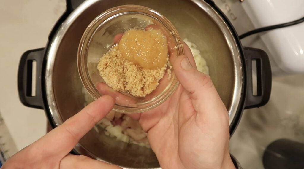 Adding crushed ginger and garlic to the pot